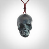 This picture shows a Black Obsidian stone skull pendant that we have hand carved. It is polished to a soft shine and is a very striking piece. Provided with an adjustable plum cord.
